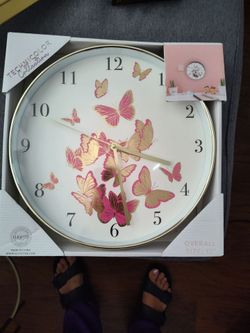 Reloj de pared de mariposas rosa con dorado.