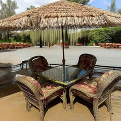 Wicker dining table with four chairs plus Tiki umbrella, and cast-iron stand 