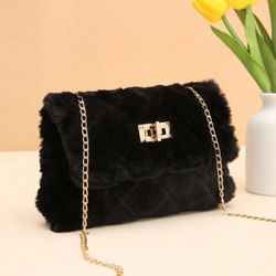 Bleach fur bag with a gold metal strap.