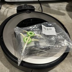 Roomba with spare filters and parts.