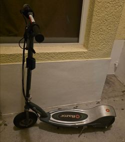 Razor E300 electric scooter featuring a gray frame and a large silver deck.