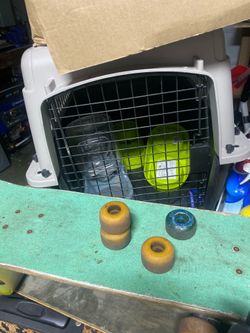 2 skateboards with extra wheels and dog crate with bowls and collars
