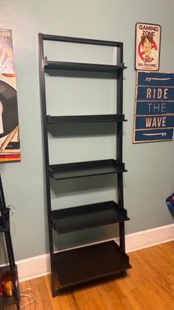 leaning black bookshelf