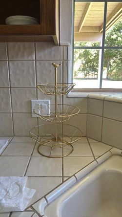 Gold dessert stand with bird on top, three tiers