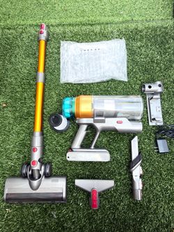 Cordless upright vacuum cleaner with a removable battery and attachments.
