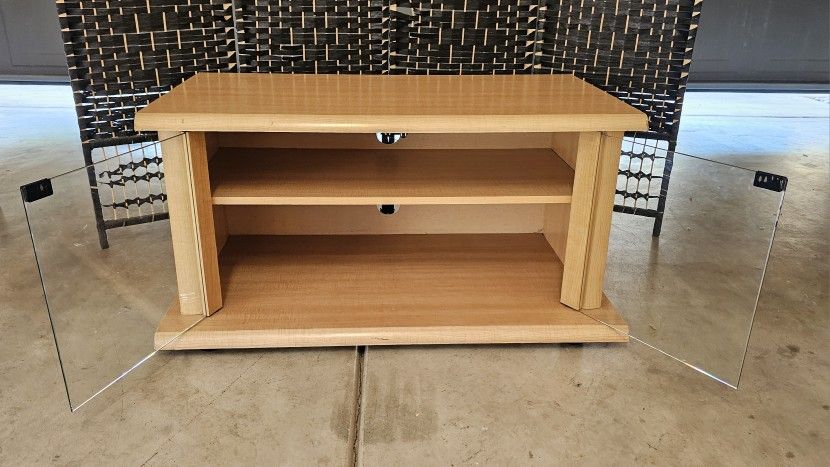 wooden TV stand with two shelves and glass doors.