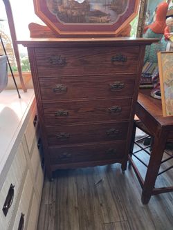 Tall antique-style oak chest with five drawers and metal handles.
