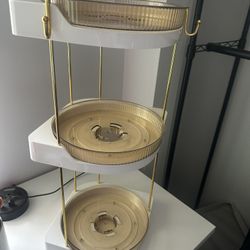 Gold and white tiered storage unit with rotating trays