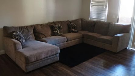 Beige-Gray Couch With Decorative Pillows And Rug