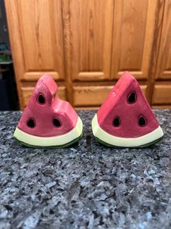 Ceramic Watermelon Slices Pair of Salt And Pepper Shakers.  Size appropriately 3 inches long, 1 1/2 inches wide and 3 1/4 inches tall.  Preowned the b