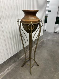 Hollywood Regency style wrought iron pedestal plant stand featuring a curvaceous Roman urn silhouette.   63” high , 15” round   $200