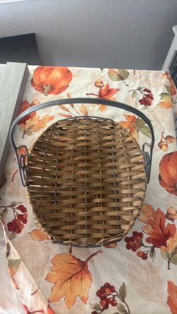 This is a Small Wicker and Metal Basket featuring a metal handle and a woven wicker base