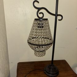 black metal table lamp with a hanging crystal chandelier shade