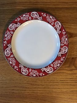 Red and White Salad Plate with Flower Designs Painted around the rim. About 8 inch diameter. Studio Nova Bandanna Red Y2209. Oven to Table. Dishwashe