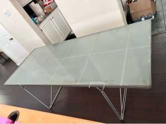 Long rectangular glass top dining table, metal base.