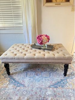Tufted Ottoman or coffee tab in natural beige linen-blend fabric.