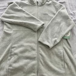 Soft light gray fleece jacket with a full front zipper. Features a stand collar and roomy hand pockets for warmth and convenience. Lightweight layer t