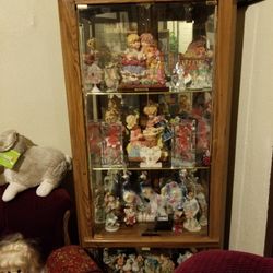 Curio cabinet ,with porcelain dolls and trinkets.