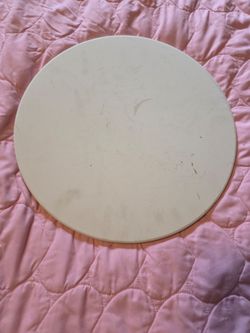 round beige pizza baking stone designed for high-heat cooking.