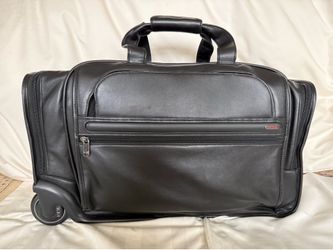TUMI Black Leather carry on bag; never used.