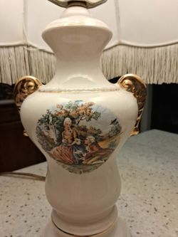 Vintage porcelain lamp with pastoral scene and fringed floral shade