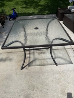 Glass top patio table with umbrella hole