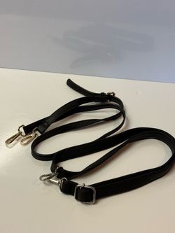 This black adjustable leather bag strap features durable swiveling clips to easily convert your handbag into a functional crossbody or shoulder bag