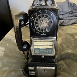 vintage Automatic Electric Company three-slot rotary dial payphone.