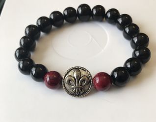 Black bracelet with 2 Burgundy’s beads and a silver charm