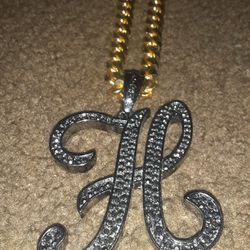 large black diamond h with gold chain