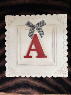 Monogram plaque with red capital letter "A” accented with a gingham fabric  black-and-white checkered bow.