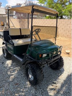Gas easy go utility cart. ST factory lifted with off-road tires.