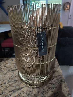 This gold-toned Tahari Home candle holder features a contemporary, wire-cage design w tags
