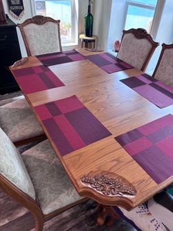 Solid oak dining table and 8 upholstered chairs in beige color.