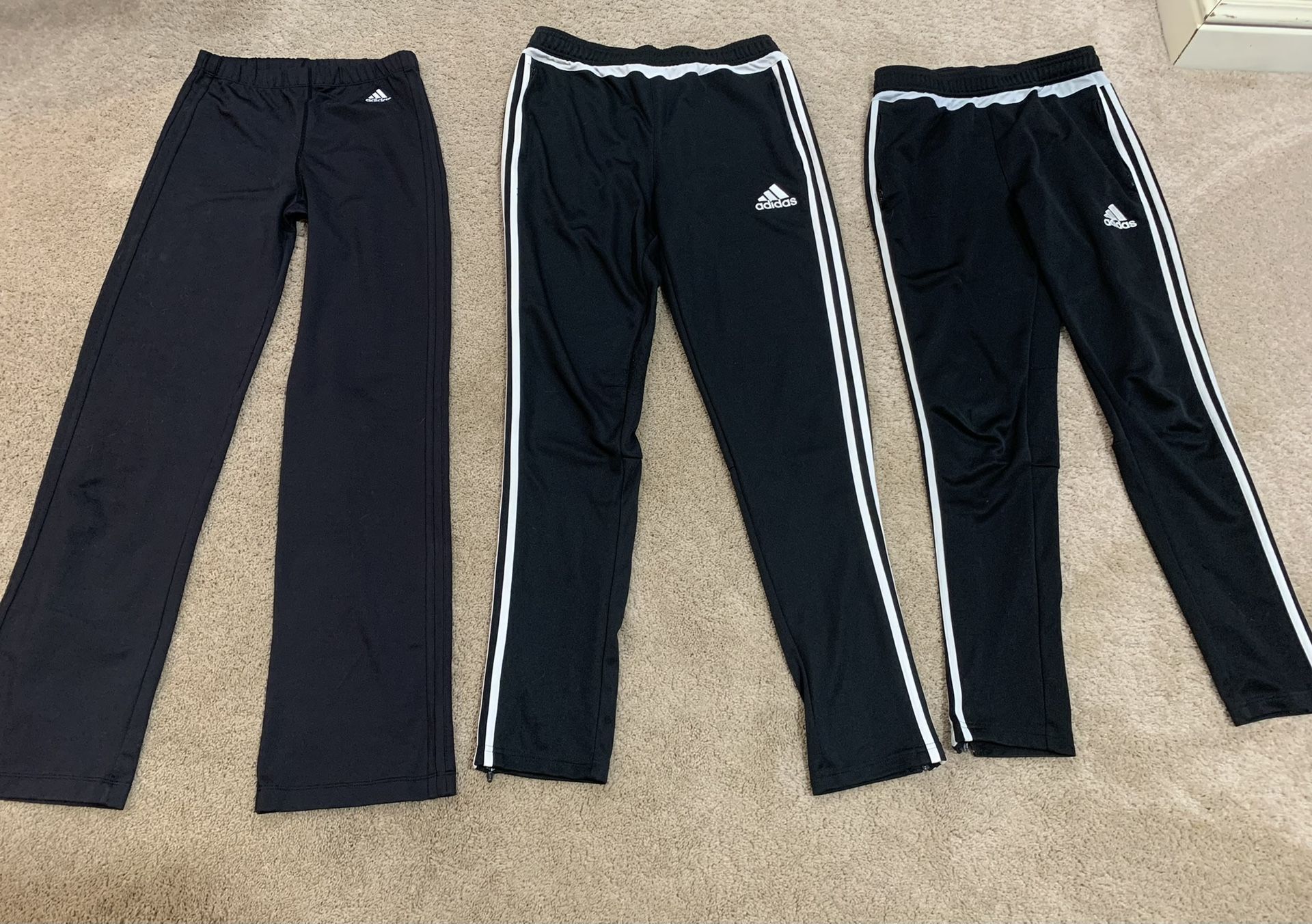 Multiple Pairs Of Adidas Pants Sizes Are From Left To Right Large Xl And Large