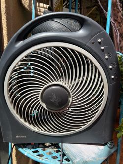 Holmes 12-Inch Blizzard Power Fan featuring a black finish and a unique rotating grill for wide area coverage.