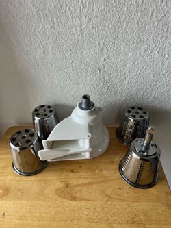 • Este es un accesorio cortador y rallador de verduras KitchenAid RVSA, que incluye varios conos de acero inoxidable para diferentes cortes.