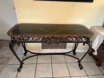 Console table w/a dark marble top with geometric inlay and a scroll-detailed wrought iron base. 19” x 48” x 30”
