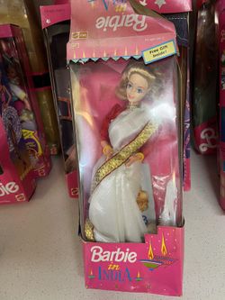Barbie in India doll, manufactured by Leo Mattel. This specific version features the doll with blonde hair, wearing a white sari with red and gold tri