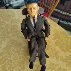 J.F.K. Doll In Rocking Chair. 1963. Doll, Chair In Good Condition.