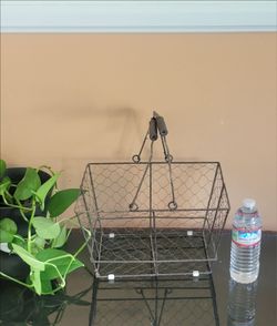 CUTE FARMHOUSE-STYLE RUSTIC METAL AND WIRE BASKET WITH WOODEN FOLD-DOWN HANDLES.