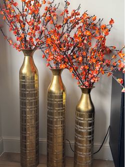 3 gold vases and orange flowers
