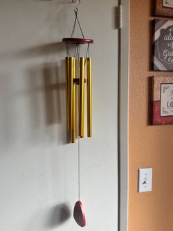Attractive gold metal wind chime for indoor or outdoor display.