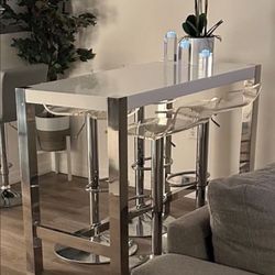 NEW WHITE LACQUER WITH CROME LEGS DINING TABLE WITH 4 ADJUSTSBLE ACRYLIC STOOL ONLY THE LACQUER TABLE COST $1000 IN ROOMS TO GO WILL SELL FOR $450