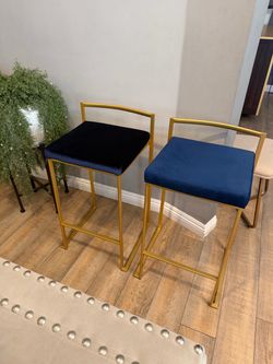 A pair of Barstools brass with navy blue velvet
