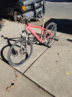 The image displays a red hardtail mountain bike.