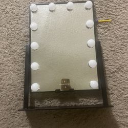 LED light-up makeup mirror with a wireless charging pad. Size 16 by 12 inches