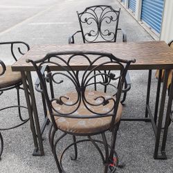 High Top Table w faux wood top and  4 wrought iron swivel chairs
