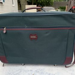 Suitcase, American tourist  26 wide 17 tall 8 deep has wheels two zipper compartments on lid 