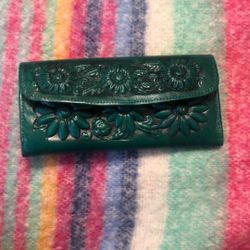 Alejandro Yeo hand-tooled leather clutch wallet with a floral design in a teal or dark green color